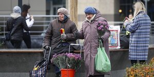Zwei alte Frauen verkaufen Blumen