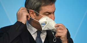 Ministerpräsident Söder nimmt eine Corona-maske ab