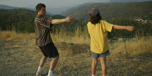 Calum (Paul Mescal, l) und Sophie (Frankie Corio) stehen vor einer grünen Gebirgslandschaft.