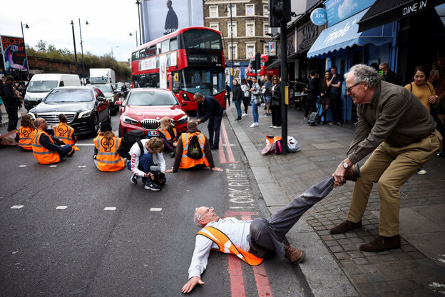 Sitzblockade ion London.- Ein Passant zieht einen Demonstranten von der Straße.