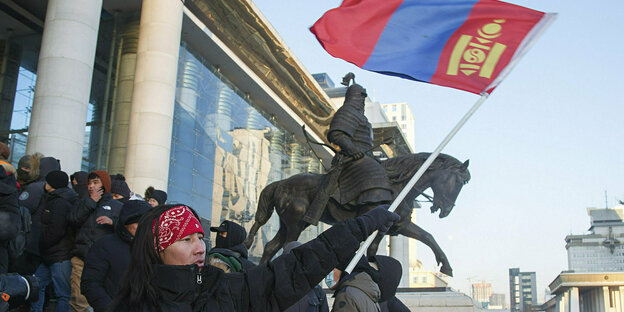 Ein Demonstrant schwenkt am Dienstag vor dem Regierungspalast die rot-blaue mongolische Fahne