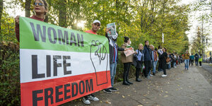Menschenkette für Iran am Tiergarten mit Transparent "Women Life Freedom"
