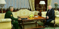 Sergei Schoigu und Alexander Lukaschenko sitzen an einem Tisch in einem prächtig möblierten Raum