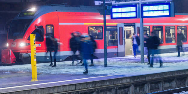 Szene am Bahnhof: Menschen gehen auf einen gerade eingefahrenen Regionalzug mit Endstation Ludwigslust zu.