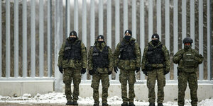 Polnische Grenzschutzbeamte vor einem Grenzzaun