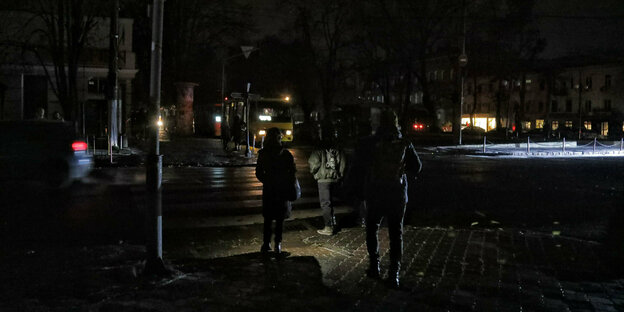 Fuß­gän­ge­r:in­nen an einer dunklen Straßenkreuzung in Odessa