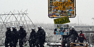 Polizisten stehen bei der Ortschaft Lützerath. Die Polizei Aachen hat sich ein Bild von der Lage in der Ortschaft Lützerath gemacht.