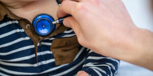 Ein Kleinkind wird mit einem Stethoskop untersucht