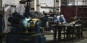 Ein Mann arbeitet an einer Werkbank in einer Fabrik für Industrieteile in Dnipro, Ostukraine