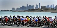 viele Rennradfahrerinnen vor der Skyline von Doha