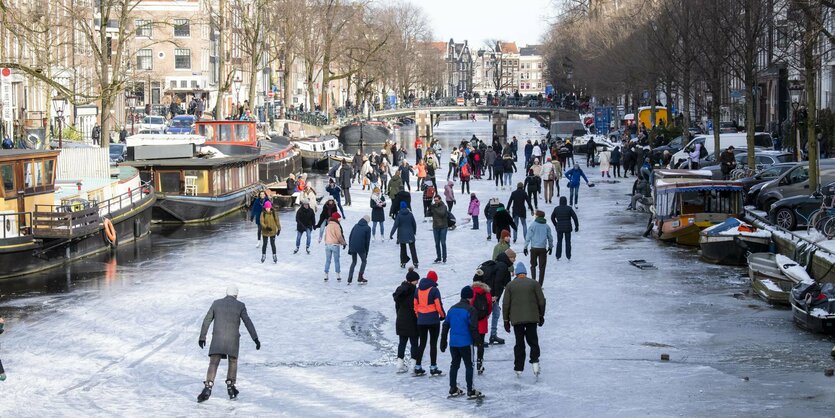 Schlittschuhfahrer auf einem vereisten Kanal in Amsterdam