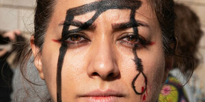 Eine Demonstrantin in Barcelona hat sich aus Protest einen Galgen auf das Gesicht gemalt.
