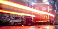 Ein Rettungswagen fährt über eine Straße und hinterlässt bewegungsinduzierte Licht-Schlieren durch die Scheinwerfer