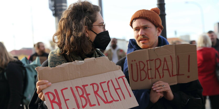 Demonstrierendehalten die Schilder "Bleiberecht" und "überall!"