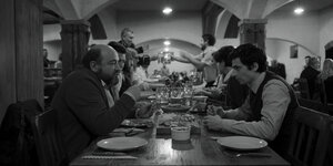 Szene aus „Orkester“ (Regie: Matevž Luzar, Slowenien 2021): Männer sitzen zusammen und essen in einer Gastwirtschaft