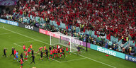 Das marokkanische Nationalteam jubelt auf dem Platz vor der Fankurve