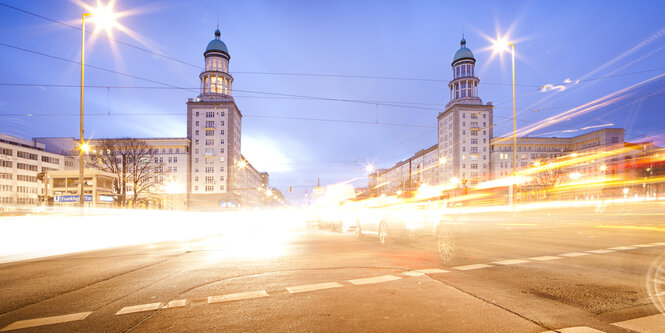 Nachtaufnahme des Frankfurter Tors mit verschwimmenden Verkehrslichtern