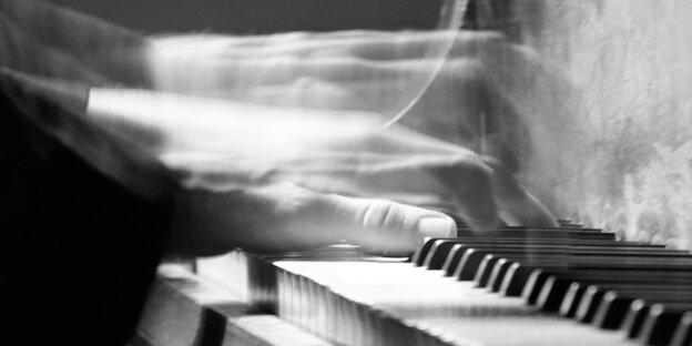 blurred hands on a piano keyboard