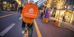 Ein Fahradfahrer mit orangfabenem Rucksack