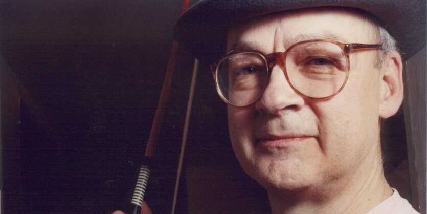 Tony Conrad mit Brille, Hut und Geigenbogen