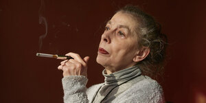Bettina Wegner raucht eine Zigarette mit Zigarettenspitze