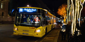 Ein als Weihnachtsmann verkleideter Busfahrer der Berliner Verkehrsbetriebe winkt im Dezember 2017 in Berlin Passanten und Touristen von seinem Fahrerarbeitsplatz aus zu.