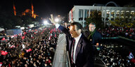 Ekrem İmamoğlu steht über einer Menge und winkt ihr zu, im Hintergrund Wahrzeichen von Istanbul