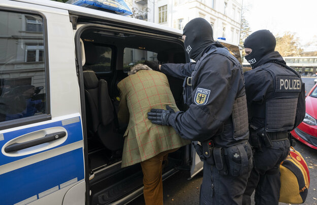 Bei einer Razzia gegen sogenannte «Reichsbürger» führen vermummte Polizisten, nach der Durchsuchung eines Hauses, einen festgenommenen Verdächtigen zu einem Polizeifahrzeug.