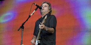 Eric Clapton bei einem Konzert auf der Bühne mit Gitarre und am Gesangsmikrofon