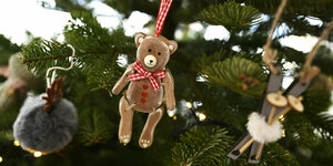 Ein Bär hängt im Weihnachtsbaum