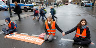 Aktivist:innen der Letzten Generation blockieren eine Straße in Berlin