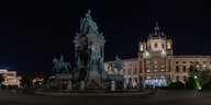 Ein beleuchteter Platz in Wien bei Nacht.