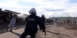 Polizist sprüht mit Pfefferspray einen Demonstranten an