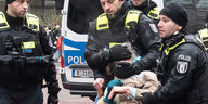 ein Polizist führt eine Aktivistin mit einem Schmerzgriff ab