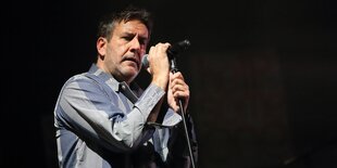 Terry Hall hält ein Mikrofon