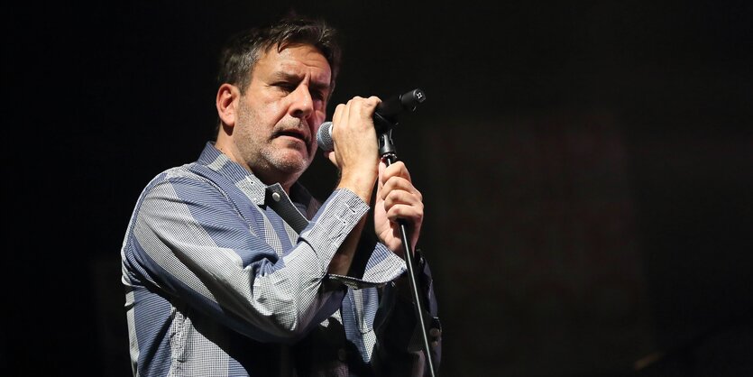 Terry Hall hält ein Mikrofon