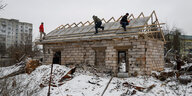 Menschen arbeiten auf dem Dach eines Hauses