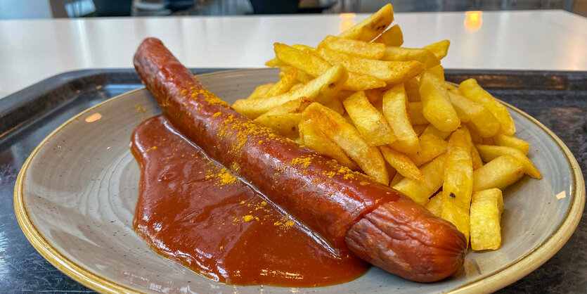 Currywurst mit Pommes auf einem Teller