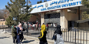 Frauen laufen an einer Universität in Kabul vorbei