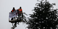 Ohne Spitze steht der Weihnachtsbaum vor dem Brandenburger Tor. Zwei Aktivisten der Umweltschutzgruppe Letzte Generation fuhren mit einem Hubwagen vor dem Tannenbaum auf dem Pariser Platz am Brandenburger Tor. Sie entrollten ein Transparent und entfernten dann die Spitze des Weihnachtsbaums.