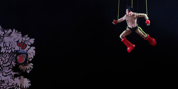 Ein Mann fliegt auf einer leeren Bühne an Seilen hägend durch die Luft: Julian Prégardien bei Proben zu Mozarts "Zauberflöte" in der Inszenierung von Yuval Sharon an der Berliner Staatsoper Unter den Linden