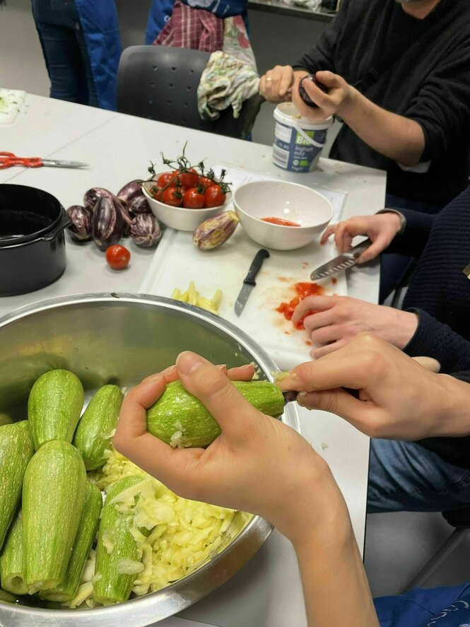 Man sieht Hände, die Zucchini aushöhlen