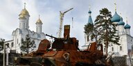 Ein zerstörter Panzer vor einer Kirche