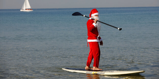 A person in a Santa suit on a SUP