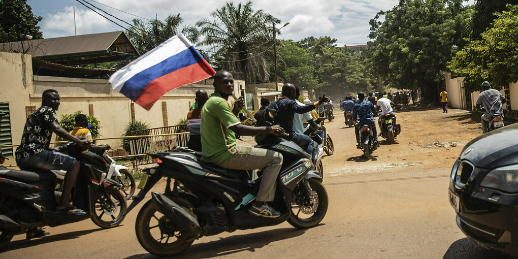 Eine Person mir russischer Flagge auf einem Motorrad