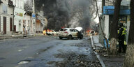 Zerbombte Straße mit brennendem Auto