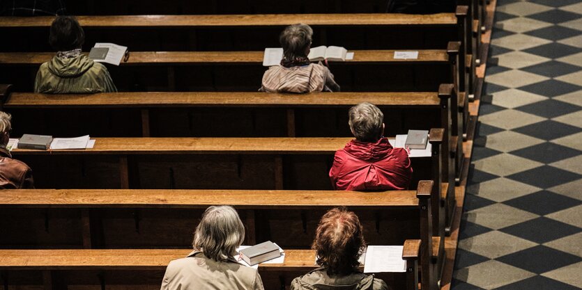 Von oben in einer Kirche aufgenommen: in den Bänken sitzen nur vereinzelt Menschen