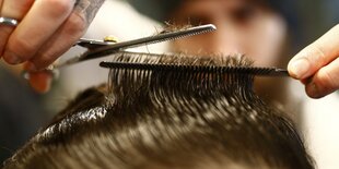 Friseur setzt die Schere an