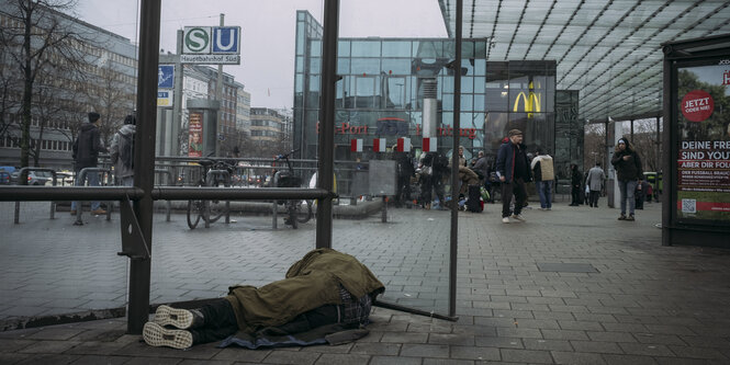 Obdachloser Mensch liget im Wartehäuschen am Hamburger Hauptbahnhof