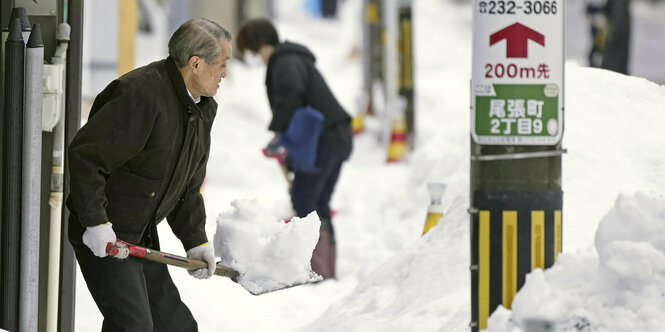 Ein Mann schaufelt Schnee